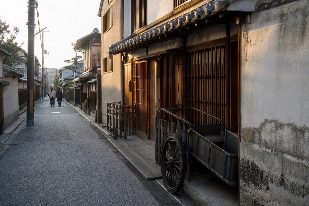 A narrow old street of traditional wooden shopfronts in the late afternoon