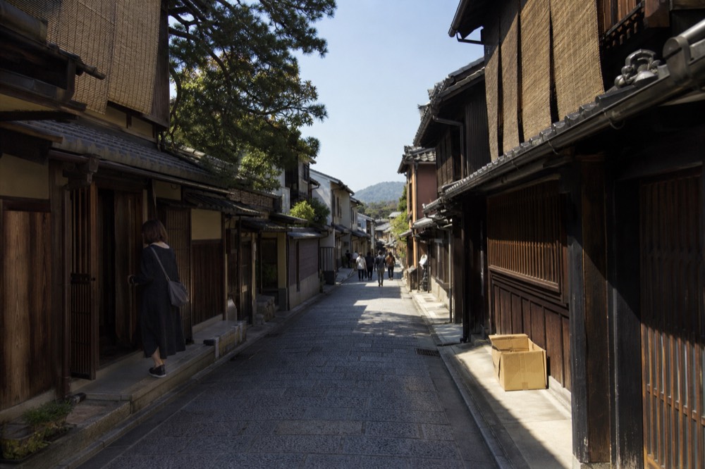 Narrow street of traditional wooden machiya shops in Kyoto at midday