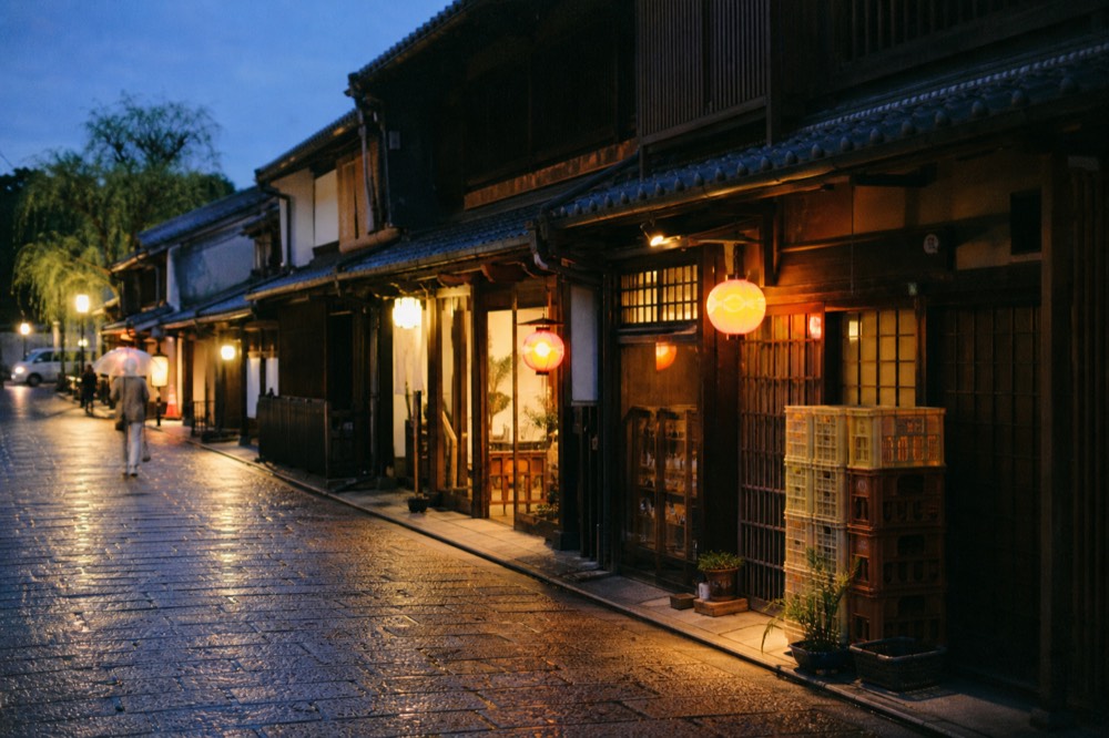 Illuminated shopfronts and lanterns on an old merchant street at dusk