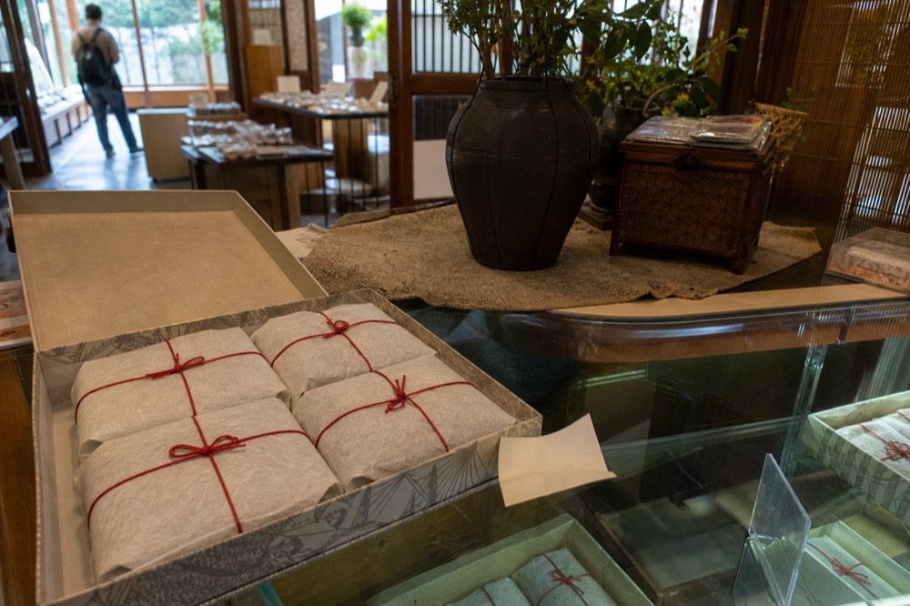 Paper-wrapped food parcels tied with cord in a gift box